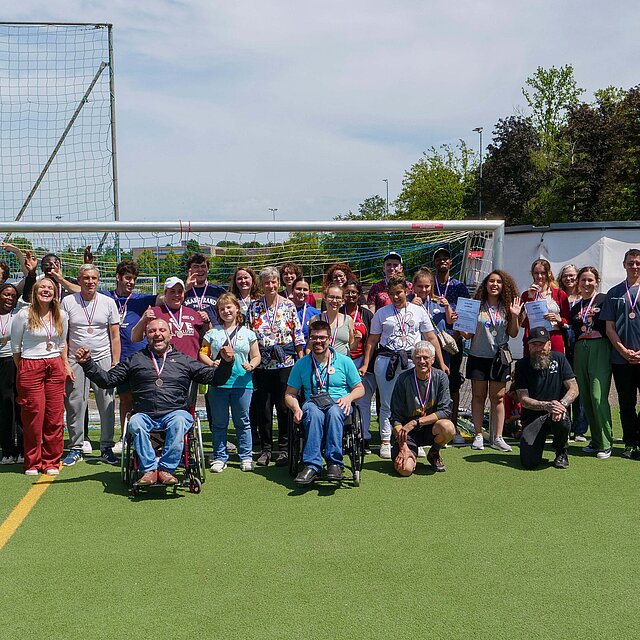 Vor einem Tor auf Kunstrasen stehen etwa 30 Personen für ein Gruppenfoto - copyright:Stadt Pforzheim