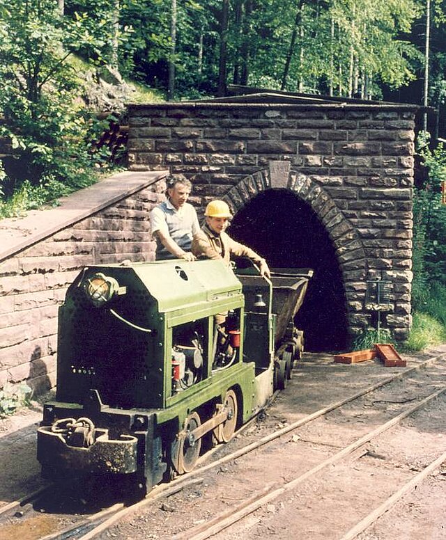 Triebwagen mit Bergwerkslore vor dem Stollenmund an der Tiefenbronner Straße