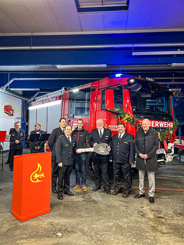 Auf dem Bild stehen obin Fix, stellvertretender Abteilungskommandant Abteilung Eutingen, Feuerwehrkommandant Sebastian Fischer, Andreas Reichenbach, Firma Magirus, Jürgen Karst, Abteilungskommandant Abteilung Eutingen sowie Carsten Löwes, stellvertretender Abteilungskommandant Abteilung Eutingen und Erster Bürgermeister Dirk Büscher vor dem neuen Feuerwehrauto.