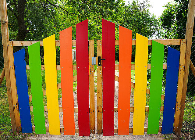 Regenbogenfarbes Eingangstor zum Naturkindergarten