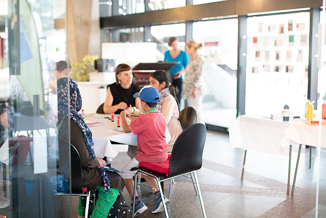 mehrere Personen im Rathauspavillon zum Tag des offnenen Rathauses, die zusammen sitzen und stehen. - copyright:Kulturamt Pforzheim