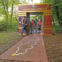 Colour photo: Hikers stand at the Golden Gate at the Kupferhammer. - copyright:Günter Beck